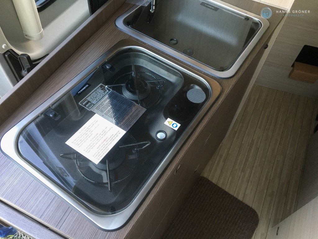 Küche im Pössl 2WIN-Plus mit Waschbecken, Gaskochflächen und Glasabdeckung