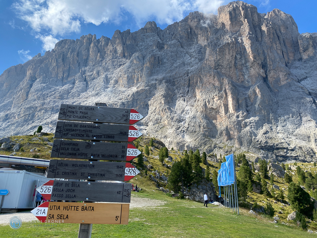 Wegweiser an der Comici Hütte mit Langkofel im Hintergrund